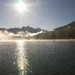 Il sole che si specchia e barca da pesca sul lago di St. Moritz. Sullo sfondo il Piz Languard. Copyright by ENGADIN St. Moritz,